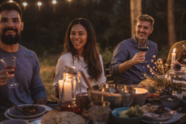 Party dinner on porch Multi ethnic group of friends have dinner party on porch, everyone enjoy in food, drinking and smiling outdoor dining photos stock pictures, royalty-free photos & images