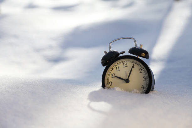 istock Closeup image of alarm clock in snow. Spring time concept image with copyspace 1126911941