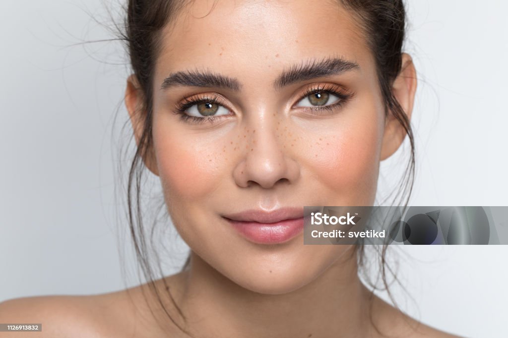 Teenage beauty Closeup studio shot of a beautiful teenage girl with freckles skin posing against a grey background Women Stock Photo