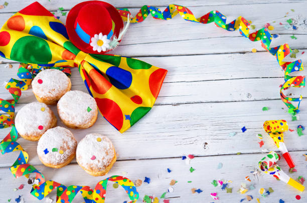 istock Krapfen, berliner or donuts with bow tie, party hat, streamers and confetti 1126914317