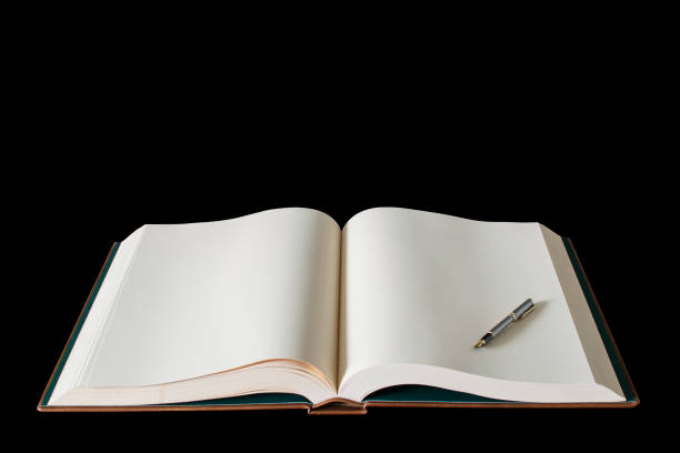 Large open spread book and fountain pen isolated on black. Clipping path available.