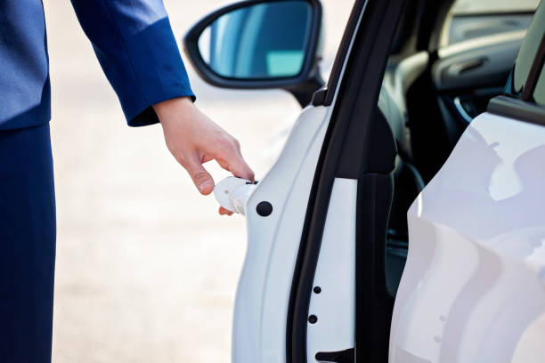 istock Young businessman opening white car door. 1126916908