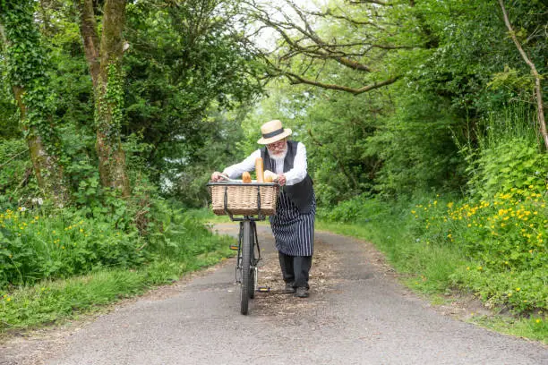 Photo of grocer on old bicycle with basket