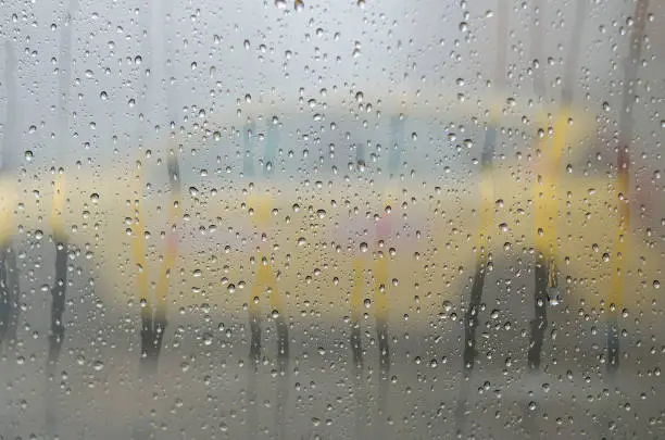Raindrops on the window glass with outline of a taxi-cab
