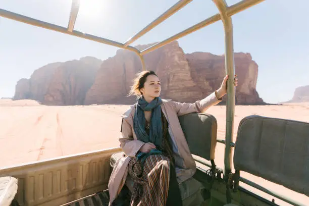 Young Caucasian woman riding in SUV through Wadi Rum desert