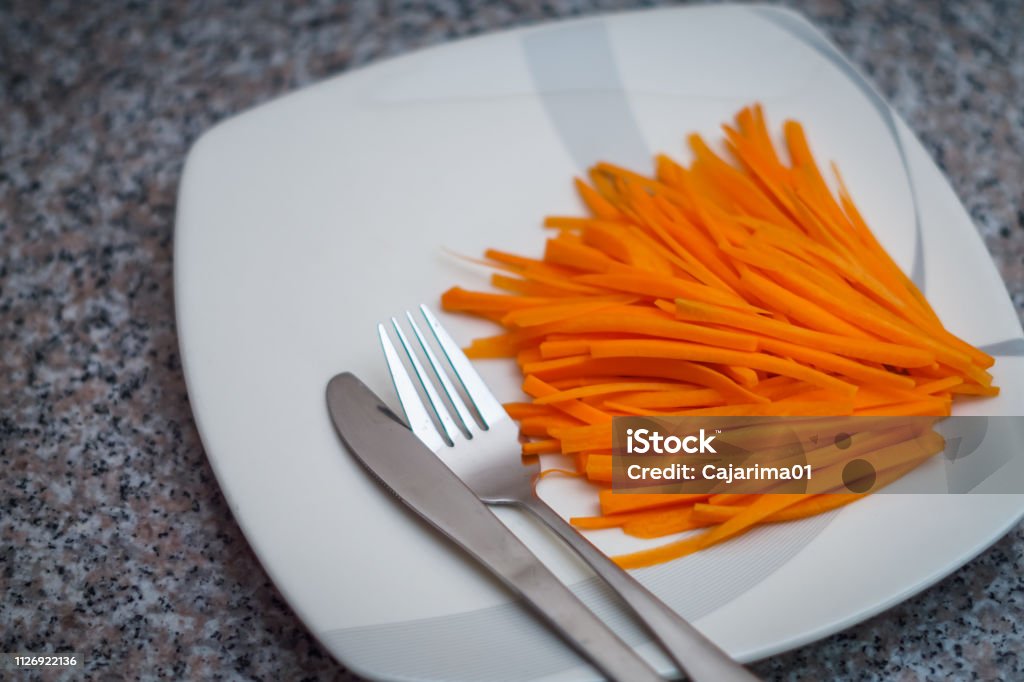 A plate of carrots with silver spoon and fork Carrot Stock Photo