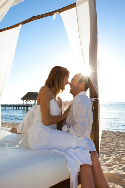 istock couple sitting on the beach on a bed 1126923469