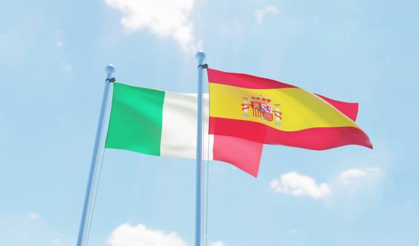 istock Spain and Italy, two flags waving against blue sky 1126924195