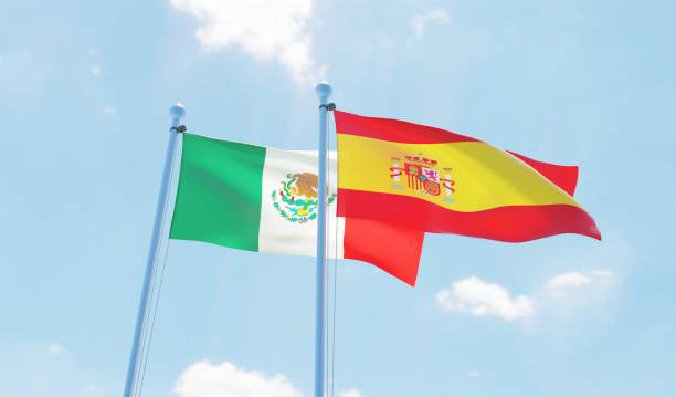 istock Spain and Mexico, two flags waving against blue sky 1126924265