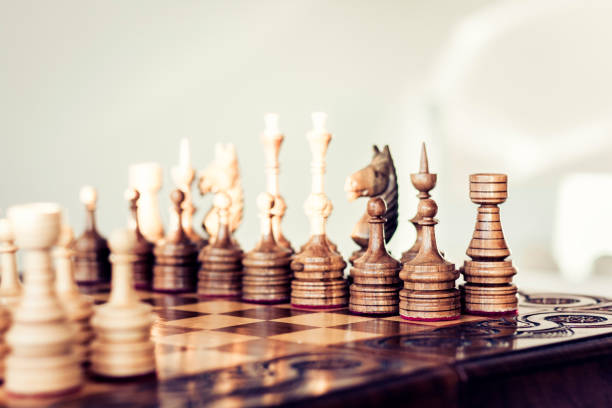 istock Wooden chess pieces on a chessboard, leadership concept on white background/ 1126924312