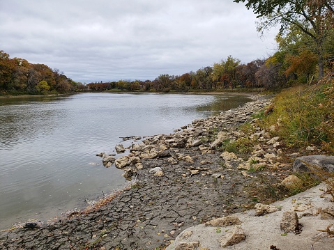 Rocky riverbank along the Assiniboine River in Winnipeg, Manitoba during late autumn