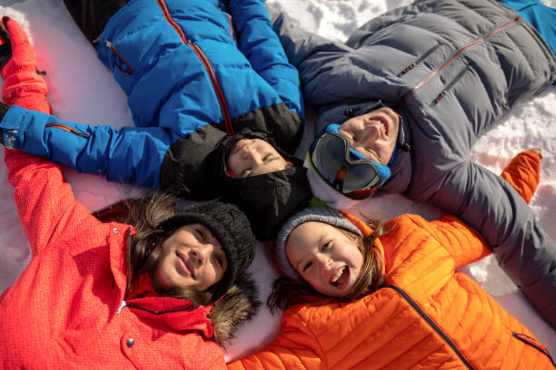 istock Happy family lying on back on snow 1126926008