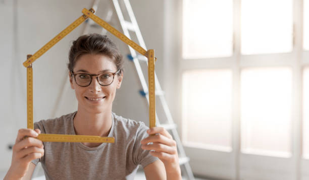 femme faisant une forme de maison avec une règle pliante - folding ruler photos et images de collection