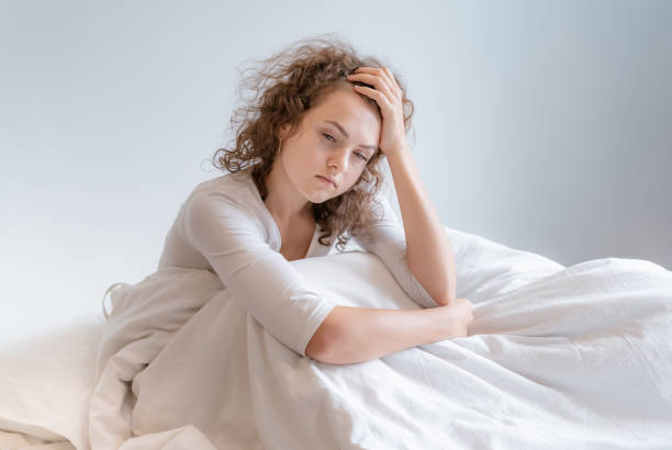 istock A woman sitting sad in bed, she regretted something. 1126930958