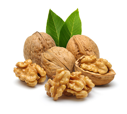 Walnuts and cracked walnut with leaves, isolated on white background