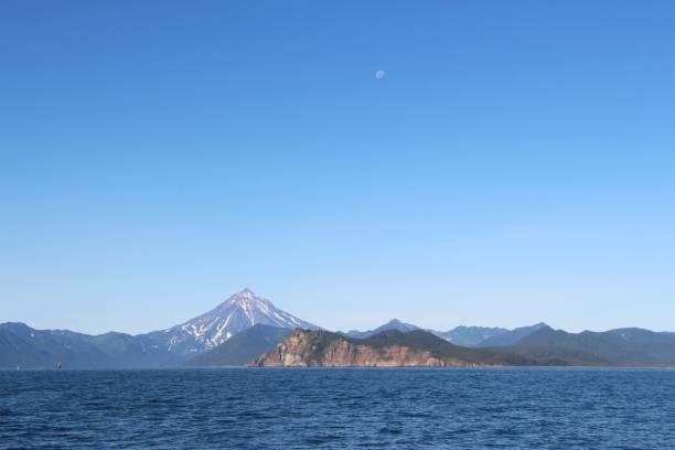 istock View of Vilyuchinsky volcano (also called Vilyuchik) from water. Moon is visible in the sky. 1126937003
