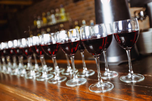 Glasses with red wine are lined up on the bar. welcome drink