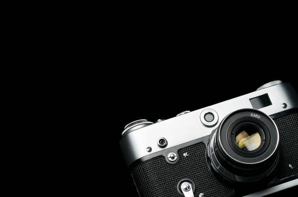 istock Old vintage shiny film camera on black background 1126937826