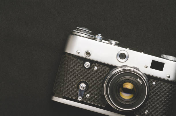 istock Old vintage film camera on black background 1126937882