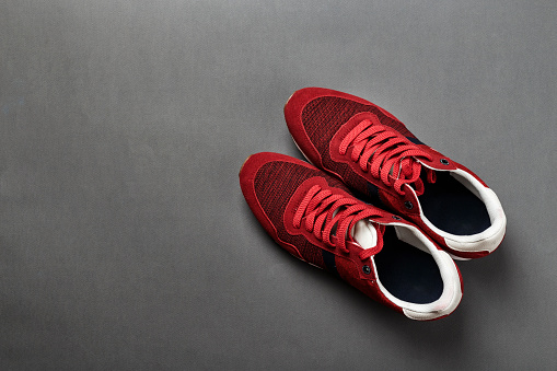 A pair of red mens sneakers on a black background. space for text