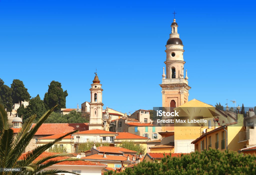The steeples of Menton. France. On the roofs of the city: St. Michael's Basilica and the penitents' chapel with Mediterranean architecture and vegetation. Alpes-Maritimes Stock Photo