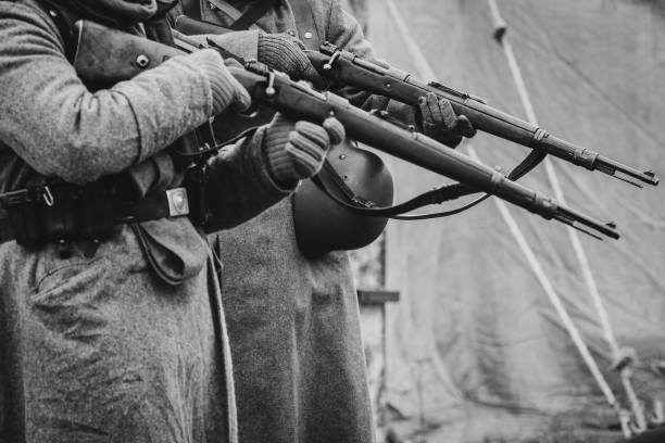 The soldiers of the German army the second world war with rifles Two German soldiers of the Second World War with rifles in their hands ready to fire. Black and white photo fascism photos stock pictures, royalty-free photos & images
