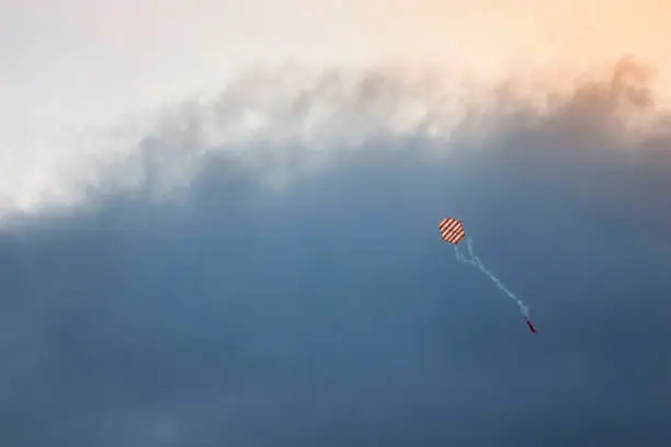Kite coming out of dark clouds.