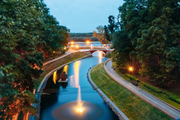 Water canal in the city park with the lights and night illumination over a stone bridge leading to the river Sozh