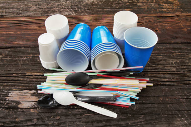Disposable plastic straws, cups, cutlery stock photo