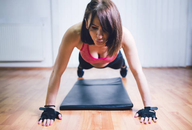 istock Girl doing pushups in gym 1126959378