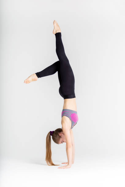 istock Young sportwoman stretching muscles on white background 1126960731