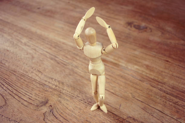 istock Wooden model doing dramatical pose on wooden table 1126964950