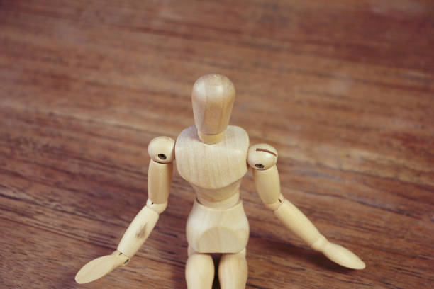 istock Wooden model doing dramatical pose on wooden table 1126965011