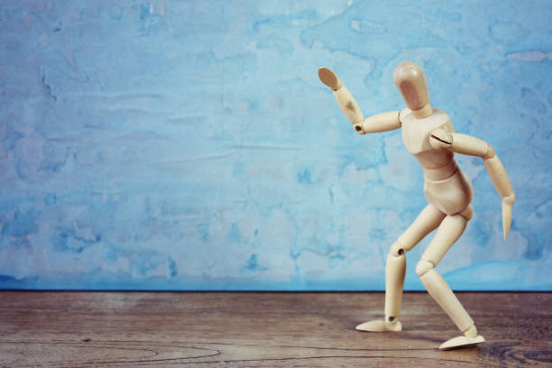 istock Expression of a wooden model doing dramatical pose on blue background 1126965077