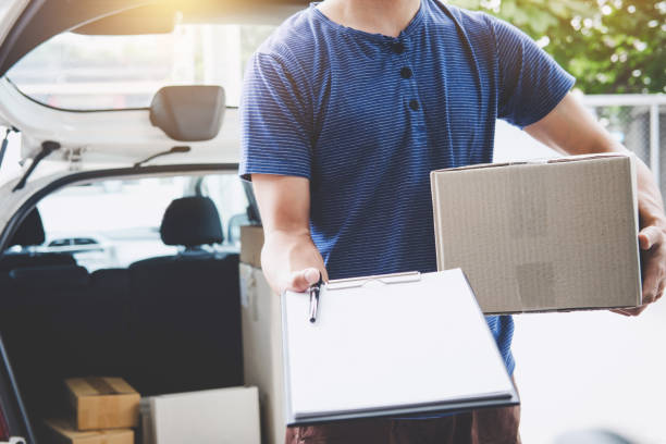 istock Home delivery service and working with service mind, deliveryman with boxes standing by in front of the customer house doors and holding clipboard 1126967164
