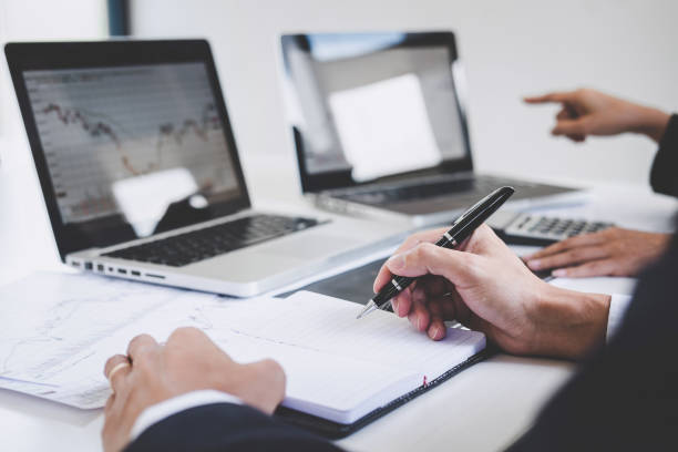 istock Business team two colleagues working with computer, laptop, discussing and analysis graph stock market trading with stock chart data, financial and investment concept 1126967186