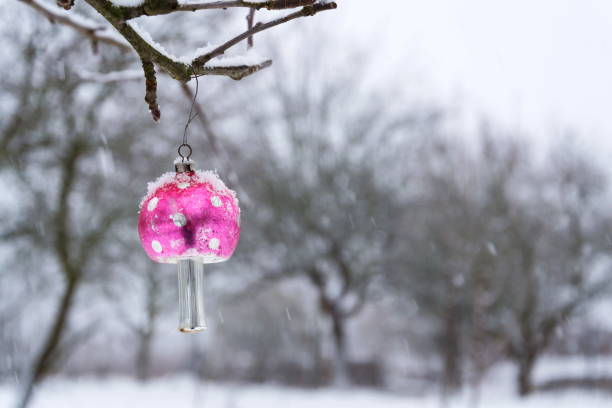 istock Vintage retro Christmas tree glass decoration snowy red toadstool fly agaric outdoors winter landscape, snow falling in background 1126967499