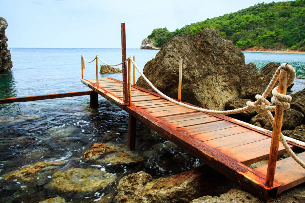 Rocky Adriatic sea coast and wooden pier.