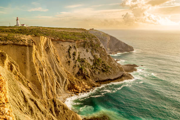 el cabo espichel. impresionante vista del faro y del paisaje marino durante la hora de oro. océano atlántico durante la puesta de sol - headland fotografías e imágenes de stock