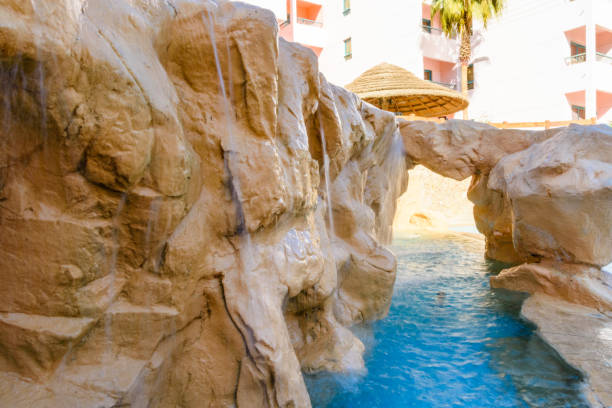 istock Small waterfall with turquoise water in the hotel pool 1126978777