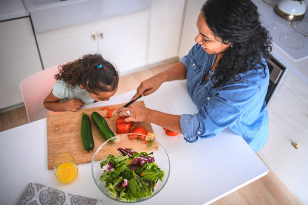 istock Girl learning to slice bell pepper from mother 1126979073