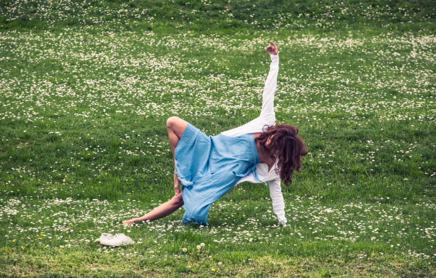 istock beautiful woman doing yoga on meadow 1126979817