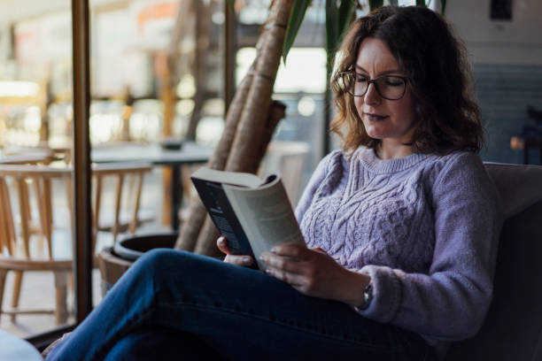 istock Woman reading book in cafe 1126980298