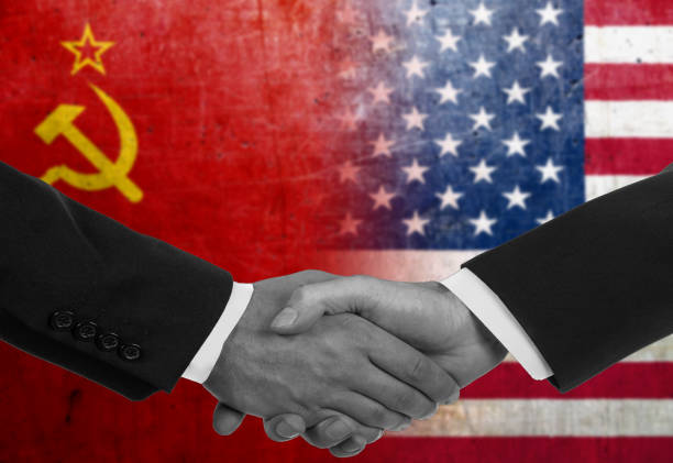Two men/politicians in suits shaking hands - Soviet Union and United States Two men/politicians in suits shaking hands with the national flags on the background former soviet union stock pictures, royalty-free photos & images