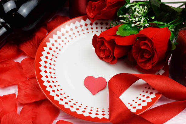 istock romantic dinner with red roses and petals on the table 1127004754