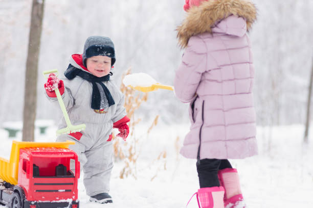 istock two little kids are playing at the snowtime 1127005438