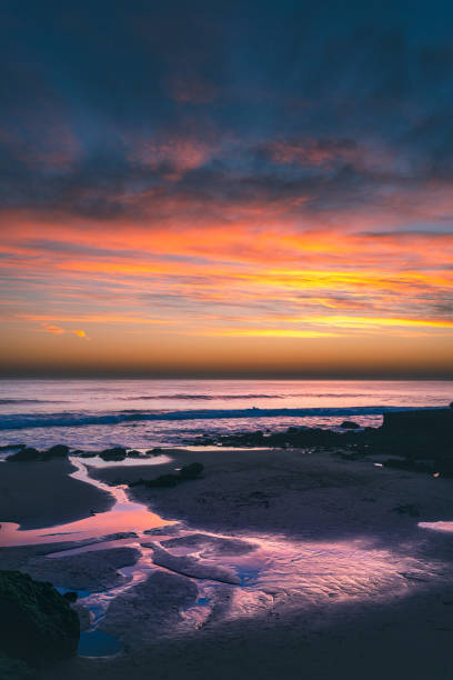 istock Sky reflection in water pool flowing to the ocean at Carcavelos beach at sunset 1127005570