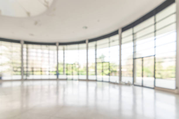 istock Blur background interior view looking out toward to empty office lobby and entrance doors and glass curtain wall 1127009260