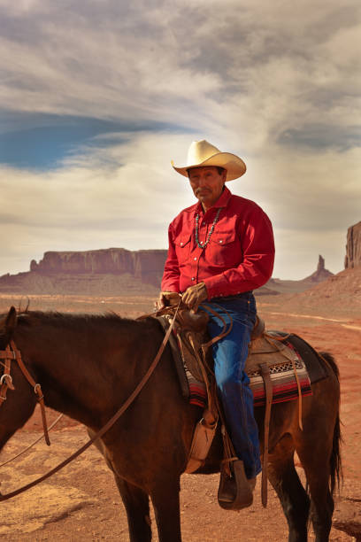 western cowboy nativo americano a cavallo al monument valley tribal park - western usa foto e immagini stock