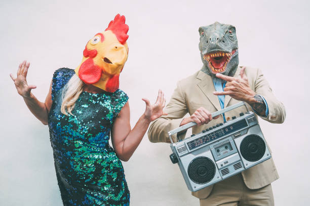 açık dans ederken çılgın kıdemli çift tavuk ve t-rex maskesi giyiyor-olgun trendy insanlar eğlenceli kutlamak ve boombox ile müzik dinleme sahip-masquerade komik tatiller saçma kavramı - tavuk kostümü stok fotoğraflar ve resimler